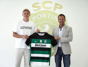 Conrad Harder holder en Sporting CP fodboldtrøje foran klubbens logo sammen med en repræsentant